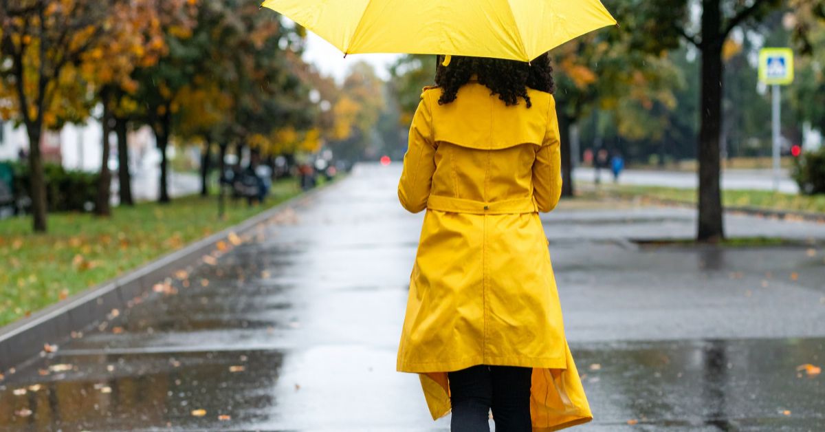 Žena u žutoj kabanici i sa žutim kišobranom