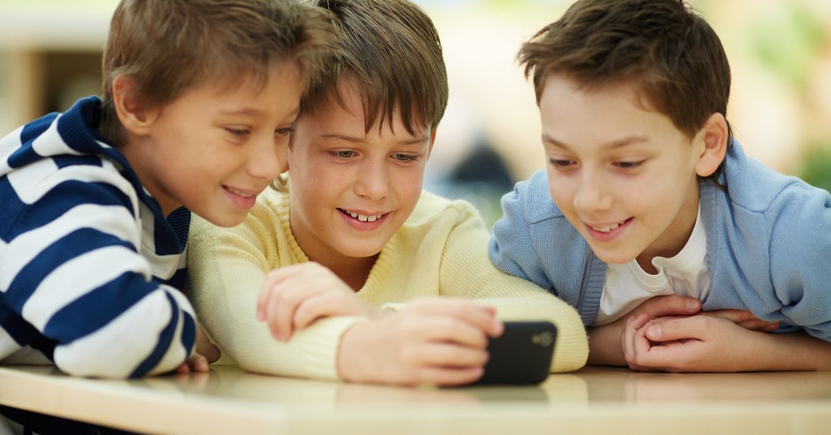 Dečaci gledaju u mobilni telefon