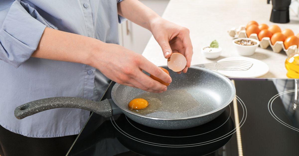 Žena prži jaja u tiganju