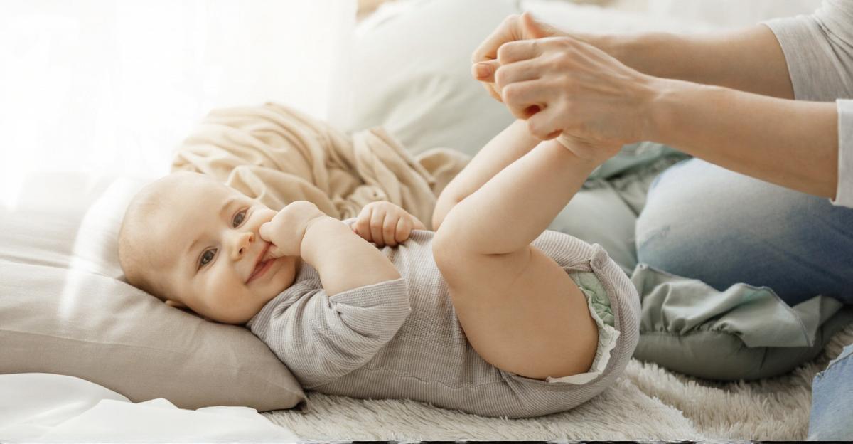 Beba leži a mama joj drži stopalca