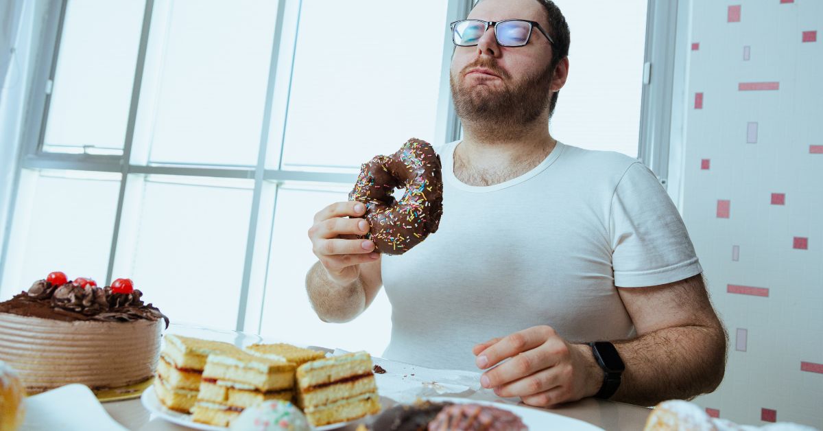 Muškarac jede krofne