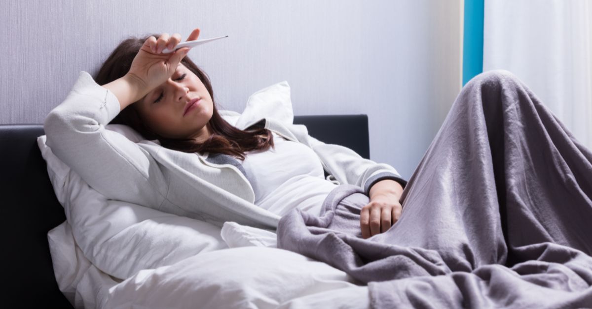 Žena leži u krevetu bolesna grip