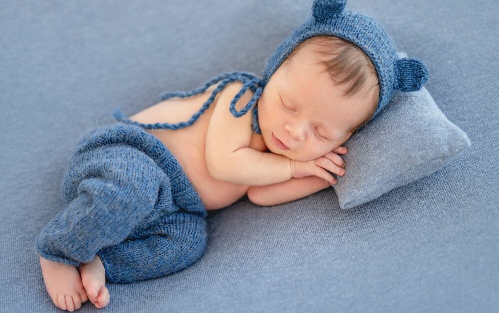 Novorođenče spava sa kapom sa ušima i pantalonicama