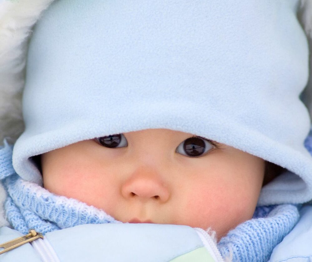 Beba sa plavom kapicom na glavi